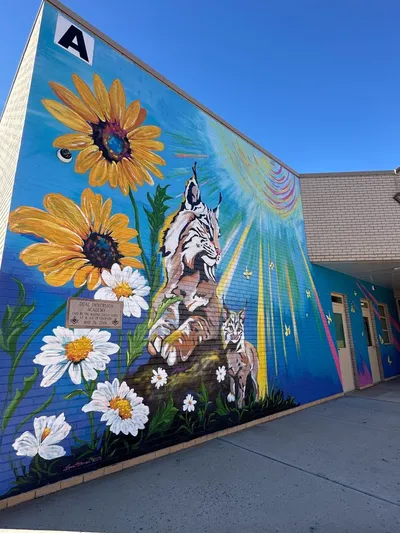 DIA — staff and families in front of the exterior mural