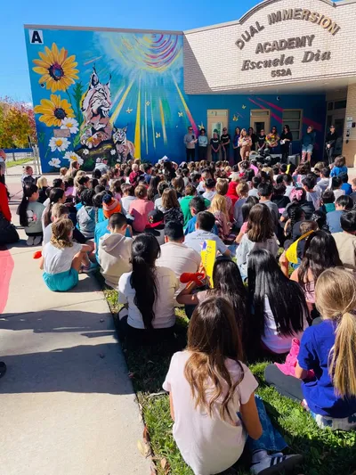 DIA — dedication gathering with students facing the mural