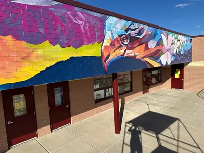 Rocky Mountain Elementary mural, silhouette of two eagles in a nest and a mother eagle perched on a branch at sunset