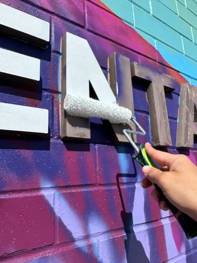 Rocky Mountain Elementary mural, in-progress shot of the school name being painted with a roller