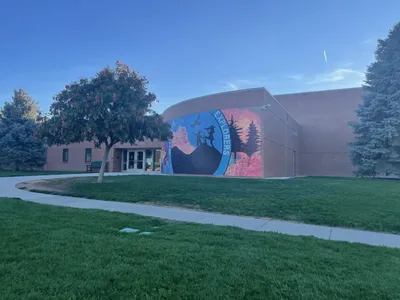 Wingate Elementary — wide view of the circular Wingate Explorers mural on the school exterior with lawn and sidewalk